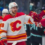 Calgary Flames center Elias Lindholm greets the bench after scoring against the Seattle Kraken during the first period of an NHL hockey game, Monday, Nov. 20, 2023, in Seattle.
