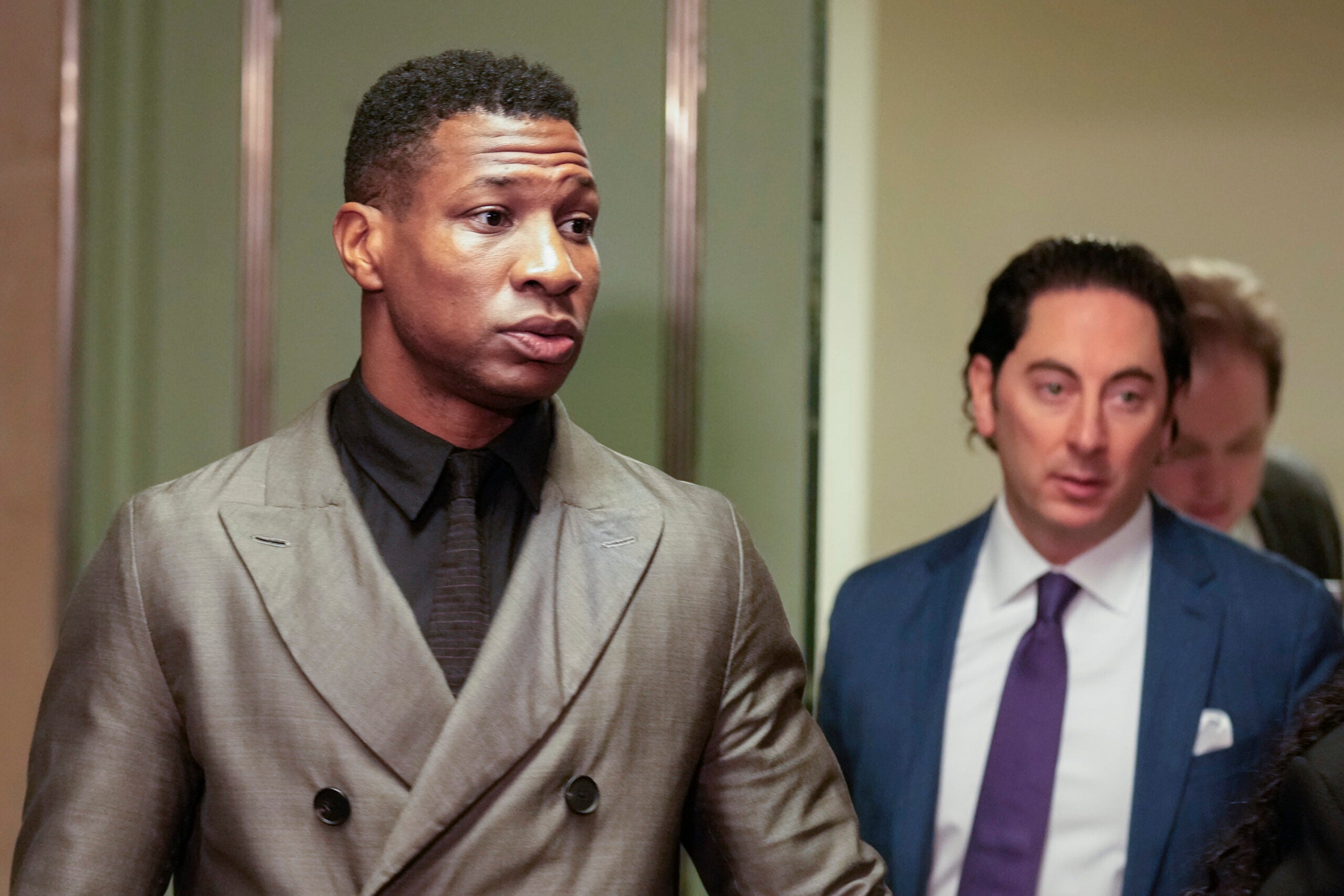 Jonathan Majors, left, enters a courtroom at the Manhattan criminal courts in New York, Monday, Dec. 18, 2023.