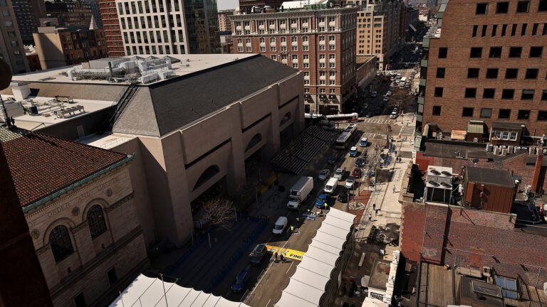 Seen from the bell tower of Old South Church, the Boylston Street finish line preparations continue. The Boston Public Library is at left. Workers prepare fresh finish line graphics on Boylston Street in advance of the Boston Marathon. It’s been years since the line has had an annual coat of new paint, with a pre-printed decal instead applied to the pavement where the runners will break the tape.