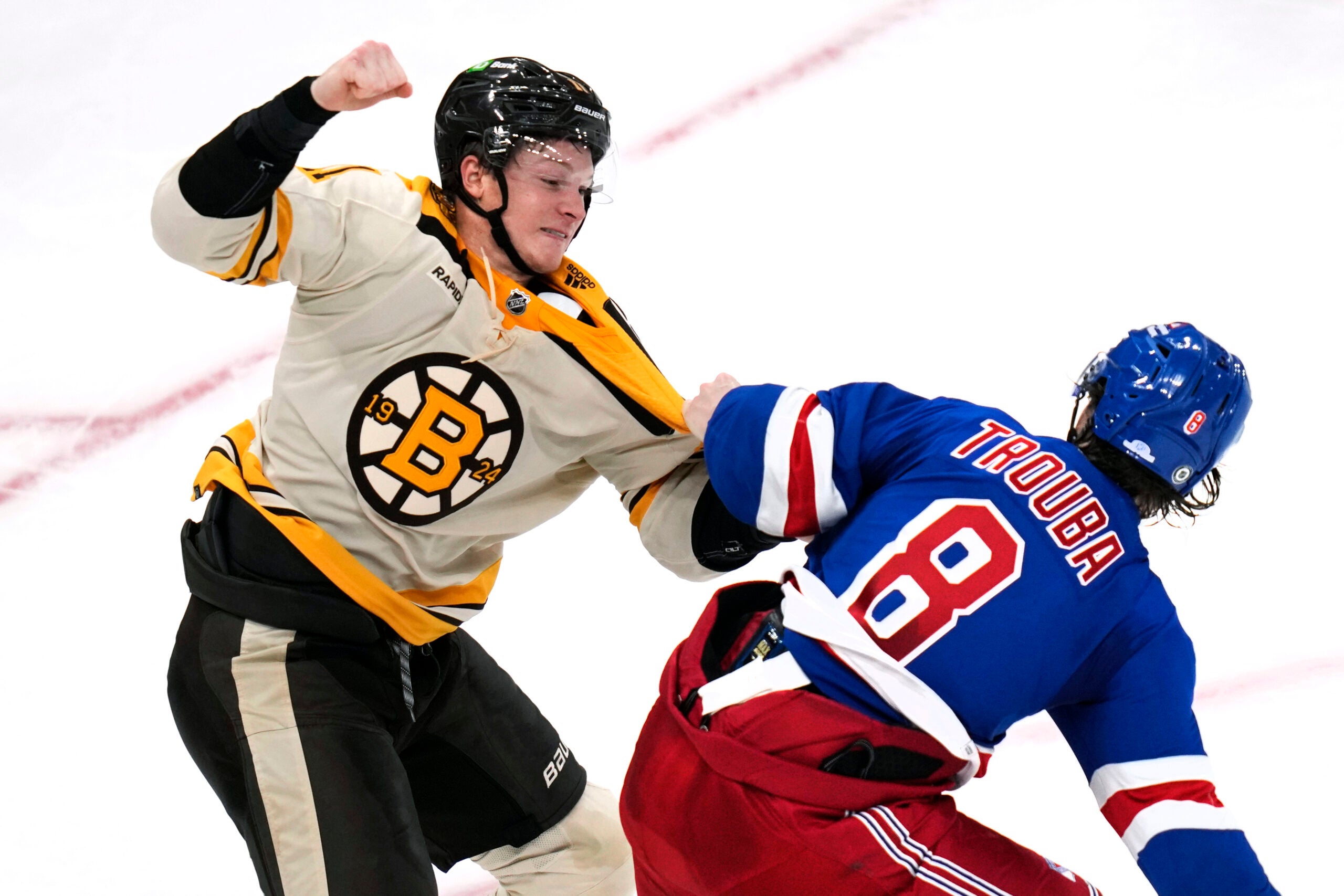 Boston Bruins center Trent Frederic, left, fights New York Rangers defenseman Jacob Trouba (8) during the second period of an NHL hockey game, Saturday, Dec. 16, 2023, in Boston.