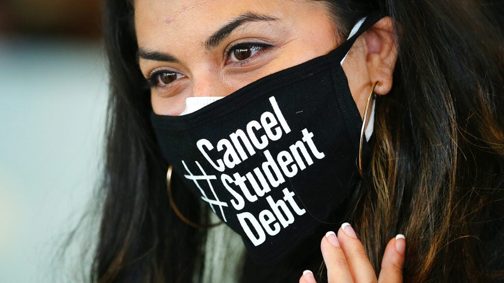 Aissa Banez listens to Senator Elizabeth Warren and U.S. Representative Ayanna Pressley as they stopped at the Grove Hall Branch of the Boston Public Library as part of a Student Debt Cancellation Tour.