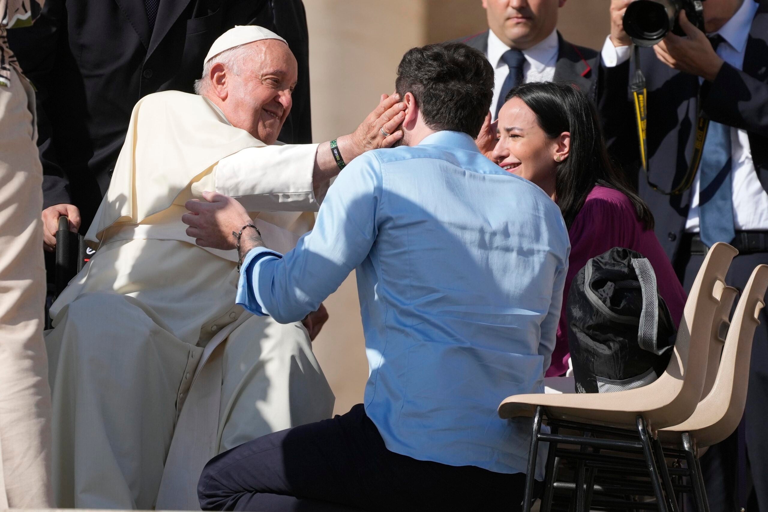 Newlyweds meet with Pope Francis in St. Peter's Square at the Vatican.